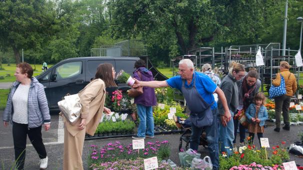 <p>Eddy Van De Bos lässt eine Besucherin an den Blumen riechen.</p>