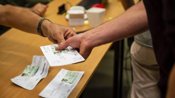 <p>Wahlaufforderungen und Personalausweise in einem Wahllokal</p>