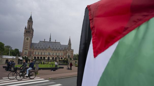 <p>Ein Demonstrant schwenkt die palästinensische Fahne vor dem Friedenspalast (hinten), in dem der Internationale Gerichtshof (Weltgerichtshof) untergebracht ist. Der Internationale Gerichtshof verpflichtet Israel zu einer sofortigen Beendigung des Militäreinsatzes in Rafah.^</p>