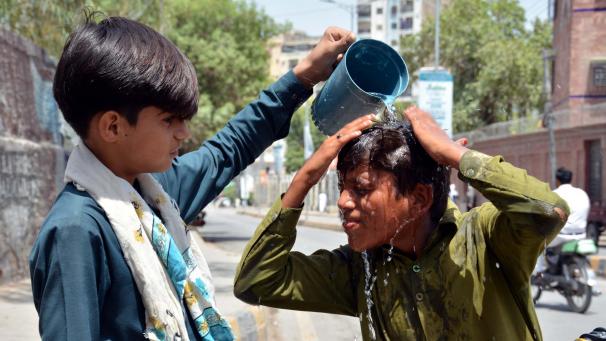 <p>Ein Junge wäscht sich in Sukkur den Kopf, um sich an einem heißen Sommertag abzukühlen.</p>