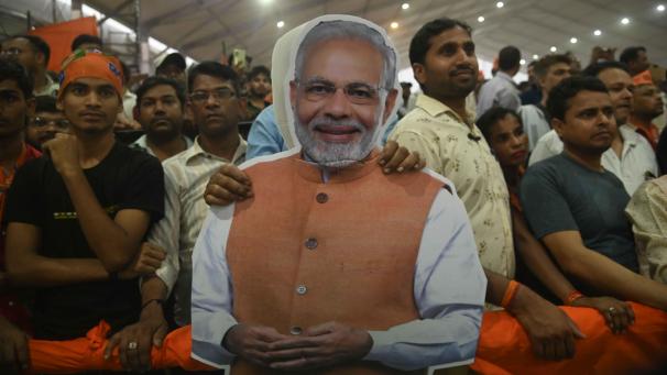 <p>Anhänger der hindunationalistischen Bharatiya Janata Party (BJP) halten bei einer Wahlkampfkundgebung ein Plakat mit dem Gesicht des indischen Premierministers Narendra Modi.</p>