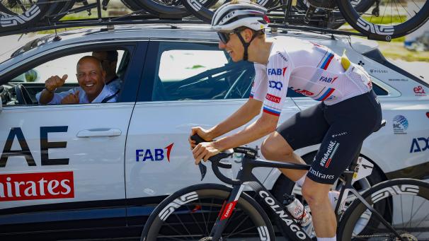 <p>Tadej Pogacar (rechts auf dem Rad) und sein Teammanager Matxin Joxean Fernandez (links im Auto) bei der 103 Katalonien-Rundfahrt</p>