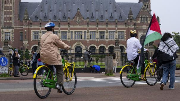 <p>Ein einsamer Demonstrant schwenkt die palästinensische Fahne vor dem Friedenspalast (hinten), in dem der Internationale Gerichtshof (Weltgerichtshof) untergebracht ist.</p>
