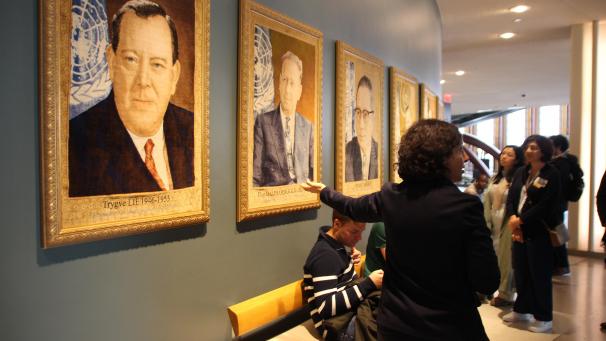 <p>Eine Tour-Führerin zeigt ihrer Gruppe eine Reihe von Tapisserie-Porträts der Generalsekretäre der UN-Geschichte im Hauptsitz der Vereinten Nationen in New York.</p>