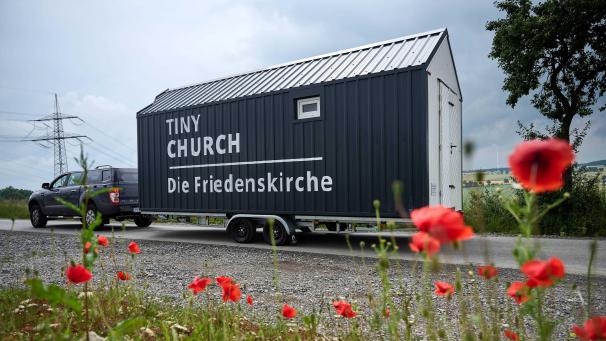 <p>Die mobile Tiny Church steht an einer Straße. Die neue Tiny Church aus Paderborn ist buchbar. Ähnliche Initiativen entstehen auch andernorts.</p>
