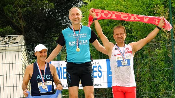 <p>Joachim Zeidler (Mitte) freut sich über seinen ersten Platz über die 1.500 Meter. Zudem belegte er über die 800 Meter den zweiten Platz.</p>