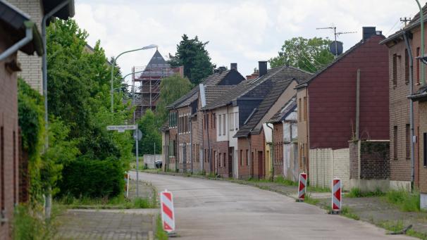<p>Zumeist unbewohnte Häuser stehen an einer Straße in Bürgewald, dem früheren Morschenich am Tagebau Hambach.</p>