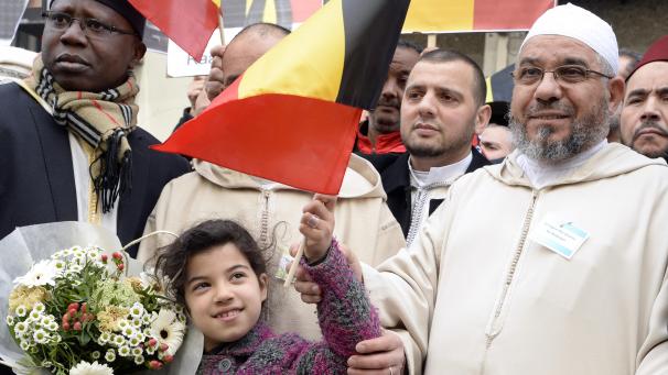 <p>Imam Mohamed Toujgani (r.) bei einer Gedenkfeier für die Opfer der Brüssseler Terroranschläge (April 2016)</p>