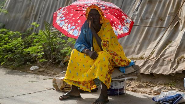 <p>Eine Frau schützt sich in Abidjan (Elfenbeinküste) vor der Sonne unter einem Regenschirm.</p>
