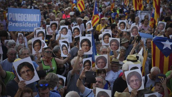 <p>Anhänger des katalanischen Unabhängigkeitsführers Carles Puigdemont halten sein Porträt, während sie auf seine Ankunft in der Nähe des katalanischen Parlaments warten, um an der Amtseinführungsdebatte teilzunehmen.</p>