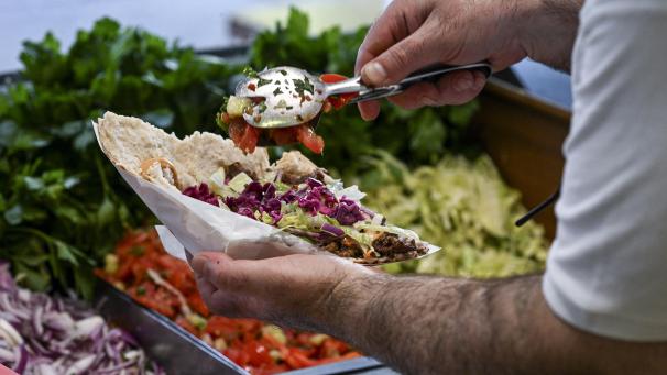 <p>Ein Döner wird mit Fleisch, Soße und Salat gefüllt.</p>