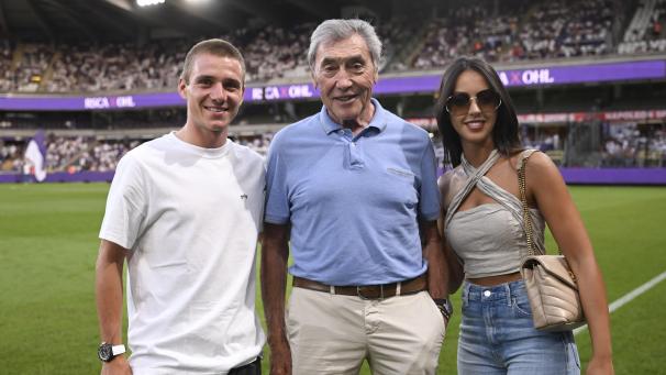 <p>Gefeierte Stars im Lotto-Park (von links): Remco Evenepoel, Eddy Merckx und Oumi Rayane, Evenepoels Ehefrau. Der Doppel-Olympiasieger führte anschließend den Anstoß aus.</p>