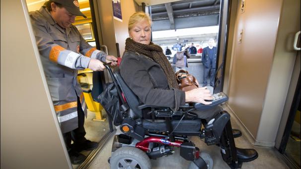 <p>Ein SNCB-Mitarbeiter hilft im Zug einer Rollstuhlfahrerin.</p>