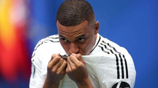 <p>Kylian Mbappe küsst bei seiner Präsentation im Santiago-Bernabeu-Stadion das Trikot von Real.</p>