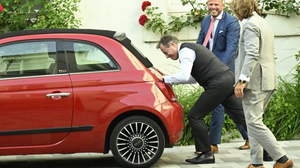 <p>Offensichtlich bewegt sich nichts. Am Tagungsort, dem föderalen Parlament, versucht Regierungsbildner Bart De Wever aus Spaß, den roten Fiat von Kammerpräsident und Pateikollege Peter De Roover zu schieben.</p>