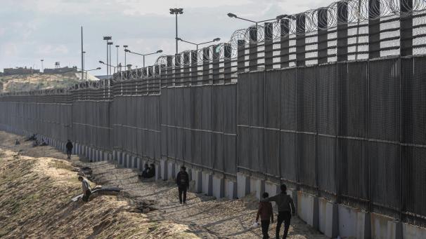 <p>Palästinenser stehen nahe der Grenze zwischen dem Gazastreifen und Ägypten.</p>