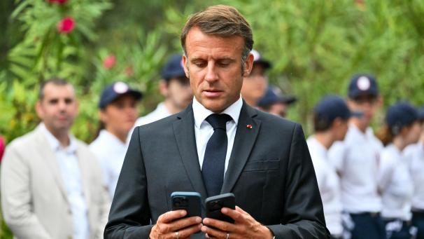 <p>Emmanuel Macron betrachtet zwei Smartphones während einer Zeremonie zum 80. Jahrestag der Landung der Alliierten in der Provence während des Zweiten Weltkriegs auf dem Nationalfriedhof Boulouris.</p>