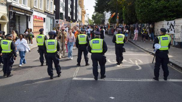 <p>Polizeibeamte beobachten die Menschenmenge am zweiten Tag des Notting Hill Carnival. Die jährliche Veranstaltung in Londons beliebtem Stadtteil Notting Hill zieht rund eine Million Menschen an und ist vor allem ein Fest der karibischen Kultur.</p>
