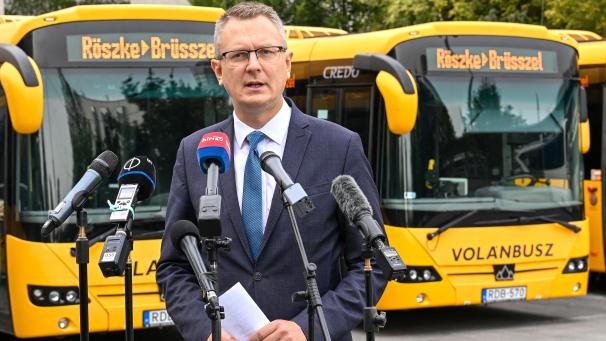 <p>Der ungarische Vize-Innenminister Bence Rétvári präsentierte medienwirksam die Busse, mit denen er Migranten nach Belgien bringen will.</p>