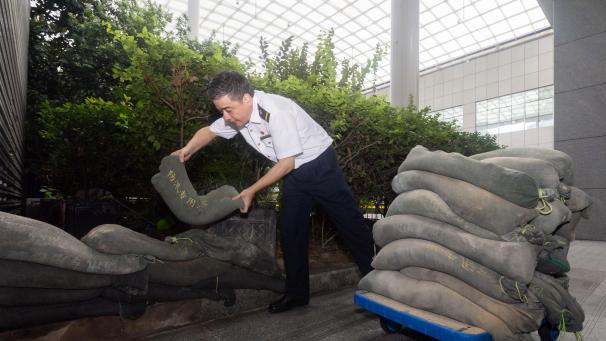 <p>Ein Mitarbeiter errichtet eine Sandsackbarriere am Shanghaier Bahnhof vor dem Eintreffen des Taifuns „Bebinca“ in der ostchinesischen Stadt Shanghai.</p>
