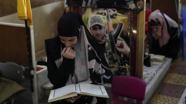 <p>Eine libanesisch-schiitische Frau sitzt in einem Friedhof und liest den Koran neben den Gräbern getöteter Hisbollah-Mitglieder in den südlichen Vororten von Beirut.</p>