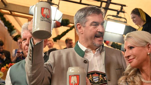 <p>Markus Söder (CSU, M), Ministerpräsident von Bayern, und seine Frau Karin Baumüller-Söder trinken neben Dieter Reiter (SPD, l), Oberbürgermeister von München, nach dem Anstich des ersten Oktoberfestfasses im Schottenhammel-Festzelt Bier. Die Wiesn findet vom 21. September bis 6. Oktober 2024 statt.</p>