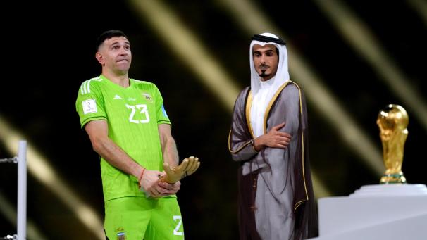 <p>Emiliano Martinez (l) jubelt mit dem Goldenen Handschuh, der ihn als besten Torhüter auszeichnete.</p>