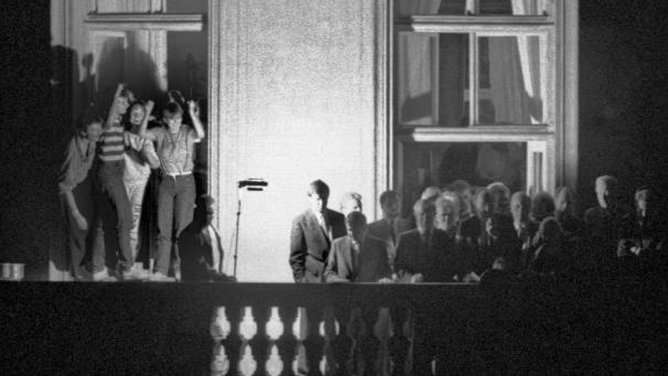 <p>Der damalige Außenminister Hans-Dietrich Genscher (unter dem Fensterkreuz rechts) steht mit anderen Politikern auf dem Balkon der bundesdeutschen Botschaft. Am 30. September 1989 hatte der FDP-Politiker dort den DDR-Bürgern im Garten verkündet, dass ihre Ausreise möglich geworden war.</p>
