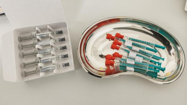 <p>Spritzen mit aufgezogenen Impfstoffen gegen Grippe (l.) und Covid (r.)</p>