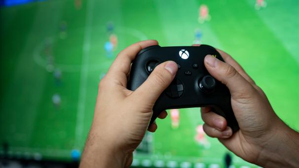 <p>Ein Mann hält einen Kontroller der Spielekonsole Xbox Series X in der Hand.</p>