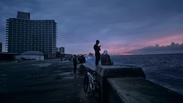 <p>Menschen stehen am Ufer in Havanna, während die Gebäude unbeleuchtet sind. In Kuba ist das Stromnetz landesweit komplett zusammengebrochen.</p>
