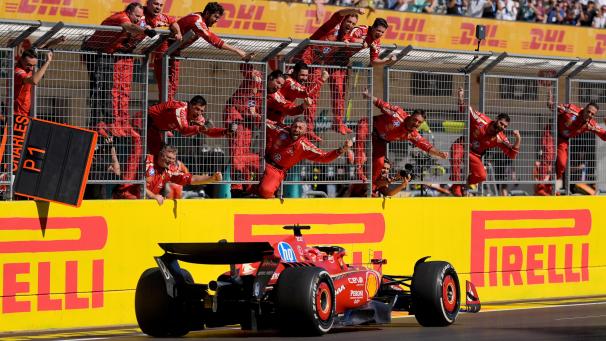 <p>Teammitglieder stehen am Zaun und feiern den Sieg des Ferrari-Fahrers Charles Leclerc aus Monaco.</p>