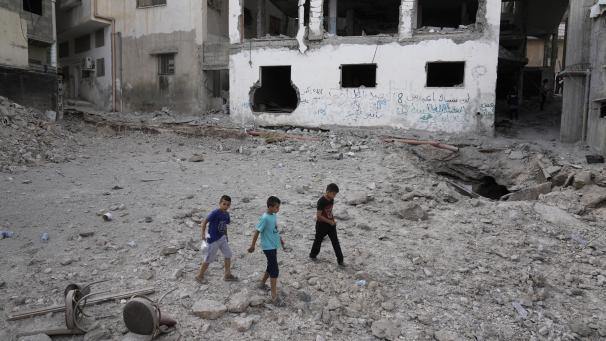<p>Palästinensische Kinder gehen nach einer israelischen Militäroperation an einem beschädigten Gebäude vorbei.</p>