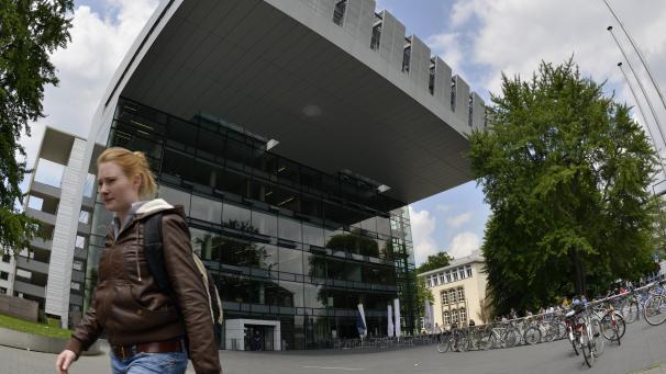 <p>Eine junge Frau geht am Studien-Service-Zentrum der Rheinisch-Westfaelische Technische Hochschule Aachen (RWTH) Aachen vorbei.</p>