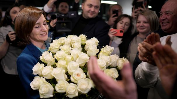 <p>Maia Sandu hält einen Blumenstrauß in der Hand, während sie mit ihren Anhängern das vorläufige Ergebnis der Stichwahl bei den Präsidentschaftswahlen feiert.</p>
