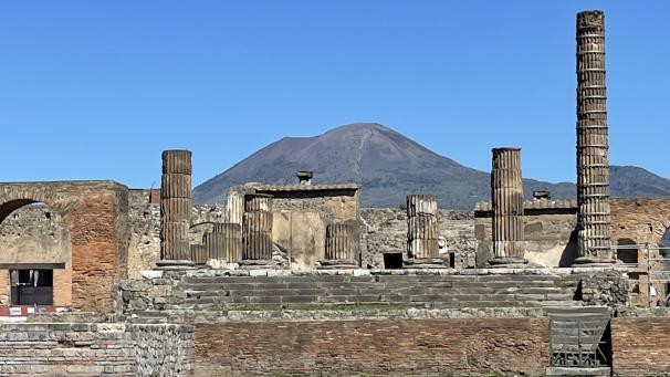 <p>Antike Gebäude in Pompeji mit dem Vesuv im Hintergrund</p>