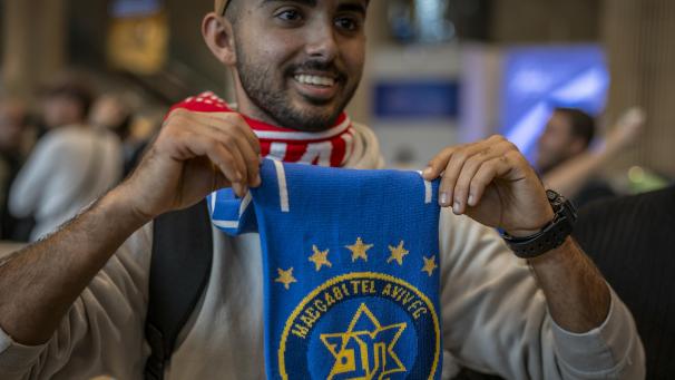 <p>Ein Fan von Maccabi Tel Aviv hält bei seiner Ankunft aus Amsterdam am Ben-Gurion-Flughafen den Vereinsschal. Nach dem UEFA-Europa-League-Spiel zwischen Ajax Amsterdam und Maccabi Tel Aviv wurden israelische Fußballfans am Donnerstag von pro-palästinensischen Demonstranten angegriffen.</p>