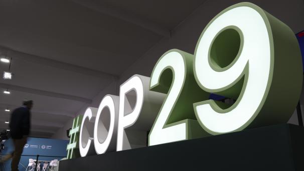 <p>Ein Teilnehmer geht in der Nähe eines Schildes für den UN-Klimagipfel COP29. Die Konferenz beginnt am Montag.</p>