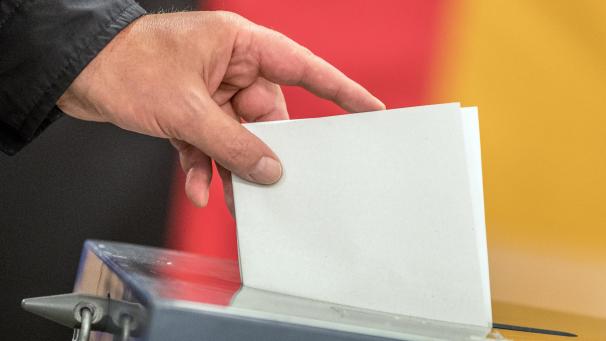 <p>Ein Wähler wirft seinen Stimmzettel zur Bundestagswahl in die Wahlurne.</p>