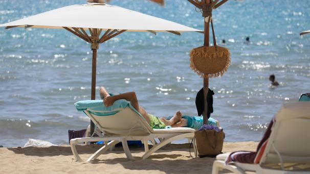 <p>Menschen sonnen sich am Strand von Arenal und baden im Meer.</p>