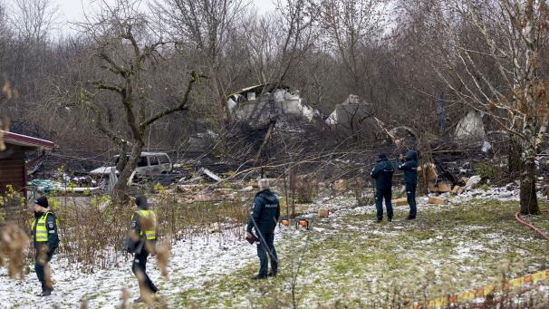 <p>Mitarbeiter des litauischen Katastrophenschutzministeriums und Polizeibeamte stehen in der Nähe der Stelle, an der das DHL-Frachtflugzeug abgestürzt ist.</p>