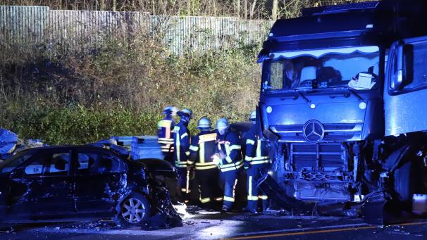 <p>Einsatzkräfte der Feuerwehr stehen neben einem Lastwagen auf der Autobahn 1 bei Hagen an der Unfallstelle.</p>