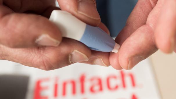 <p>Ein Mann entnimmt bei einem Heimtest eine Blutprobe, um sich zusätzlich mit einer Urinprobe und einem Rektal- und Rachenabstrich anonym auf Geschlechtskrankheiten untersuchen zu lassen.</p>