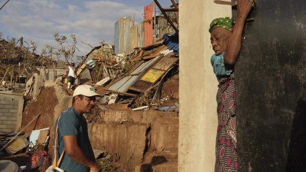<p>Menschen gehen nach dem Zyklon „Chido“ an den Trümmern des Kaweni-Slums am Rande von Mamoudzou auf der französischen Insel Mayotte im Indischen Ozean vorbei.</p>