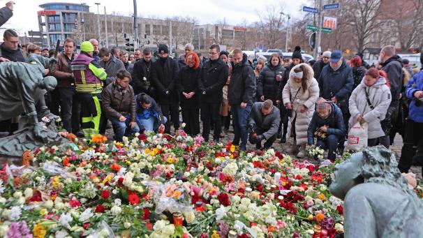 <p>Menschen legen am offiziellen Trauerort vor der Johanniskirche in Magdeburg Blumen und Kerzen ab.</p>