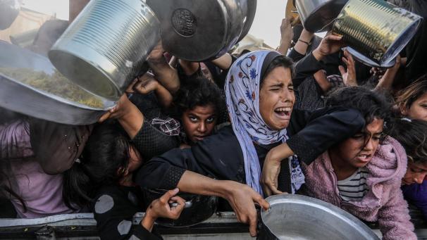 <p>Vertriebene palästinensische Kinder drängeln sich, um Mahlzeiten von der Rafah Charitable Kitchen (Tekia) in Chan Jounis zu erhalten.</p>