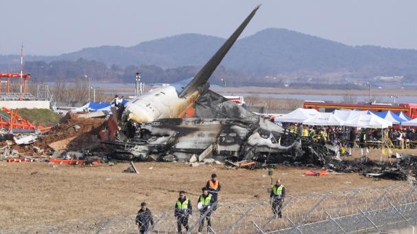 <p>Feuerwehrleute und Rettungskräfte arbeiten an dem Wrack eines Flugzeugs auf dem internationalen Flughafen von Muan.</p>