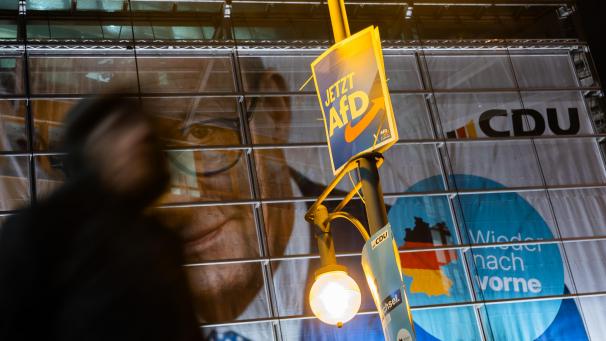 <p>Bei einer Demo zur Migrationspolitik vor der CDU-Zentrale ist ein AfD-Wahlplakat vor dem Porträt von Friedrich Merz zu sehen. Der Bundestag hatte am Mittwoch mit Unterstützung der AfD einem Antrag der Union zugestimmt, der Zurückweisungen von Asylsuchenden an den deutschen Grenzen vorsieht.</p>