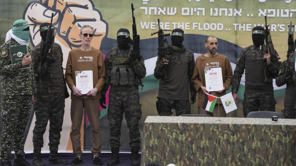 <p>Die israelischen Gefangenen Ohad Ben Ami (3.v.l) und Eli Sharabi (3.v.r), die seit dem 7. Oktober 2023 von der Hamas im Gazastreifen als Geiseln gehalten werden, werden von Hamas-Kämpfern eskortiert, bevor sie dem Roten Kreuz im zentralen Gazastreifen übergeben werden.</p>