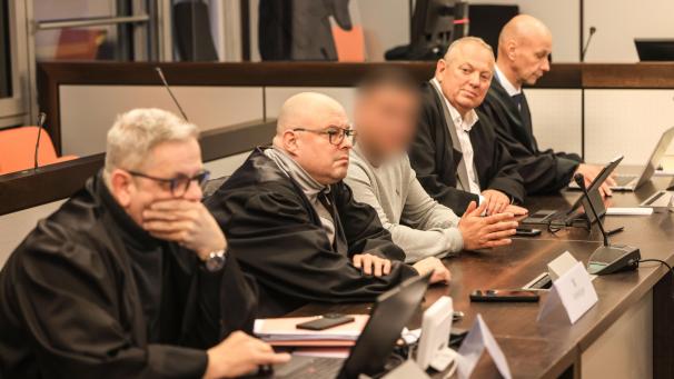 <p>Einer der drei Angeklagten (Mitte) sitzt vor der Urteilsverkündung im Gerichtssaal des Amtsgerichts zwischen Anwälten.</p>
